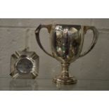 A silver twin handled trophy cup and an ashtray.