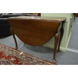 A Georgian style mahogany oval drop leaf gateleg dining table on carved cabriole legs with pointed