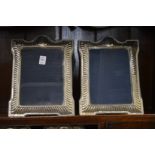 A pair of large silver photograph frames.