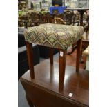 An upholstered mahogany framed stool on tapering square legs.