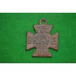 An unusual cast metal badge, one side embossed 'for brave deeds' the other side 'liar'.