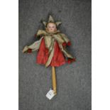 A Victorian children's toy modelled as a jester with porcelain head and turned wood handle.