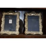 A pair of silver photograph frames with embossed decoration.