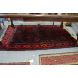 A Persian design rug with dark blue ground and stylised decoration 200cm x 130cm.