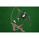 A filigree silver pendant and two crosses.