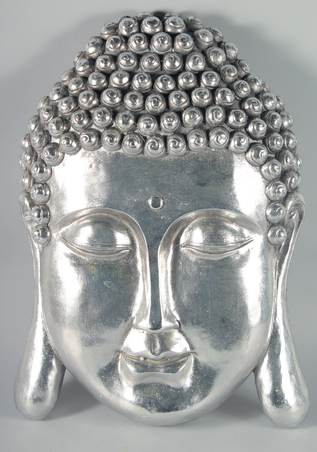 A SILVERED WALL BUDDHA HEAD 24ins long.