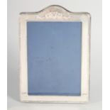 A LARGE SILVER UPRIGHT PHOTOGRAPH FRAME with ribbons motif. 7ins x 6.5ins.