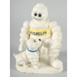 A PAINTED CAST IRON MICHELIN MAN with a dog. 8ins high.