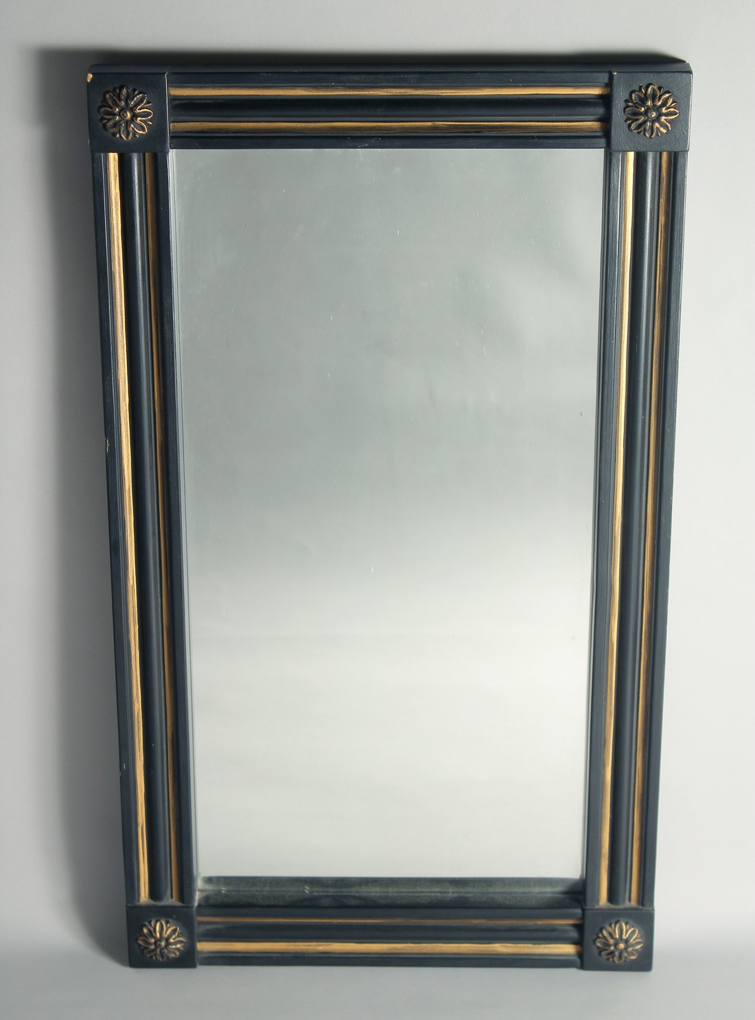 A GOTHIC DESIGN BLACK AND GILT UPRIGHT MIRROR. 2ft 7ins high, 1ft 6ins wide.