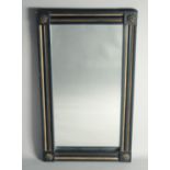 A GOTHIC DESIGN BLACK AND GILT UPRIGHT MIRROR. 2ft 7ins high, 1ft 6ins wide.