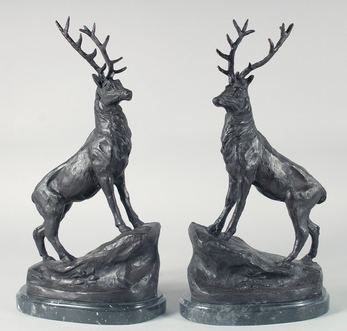 AFTER J. MOIGNIEZ. A PAIR OF BRONZE STAGS on a marble base. 17ins high.