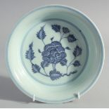 A CHINESE BLUE, WHITE AND COPPER RED BOWL, decorated with central flower, the base inscribed, 22.5cm