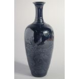 A CHINESE AUBERGINE GLAZE PORCELAIN VASE, with raised decoration depicting dragons amongst waves,