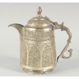 AN ISLAMIC WHITE METAL LIDDED JUG, embossed and chased decoration, 25cm high.