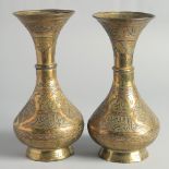 A PAIR OF CAIROWARE SILVER AND COPPER OVERLAID BRASS VASES, with panels of calligraphy, 23cm high.