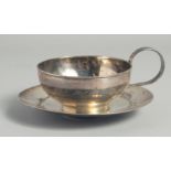 A LARGE IRAQI SILVER CUP AND SAUCER, with engraved decoration of camels and boats, weight 220g