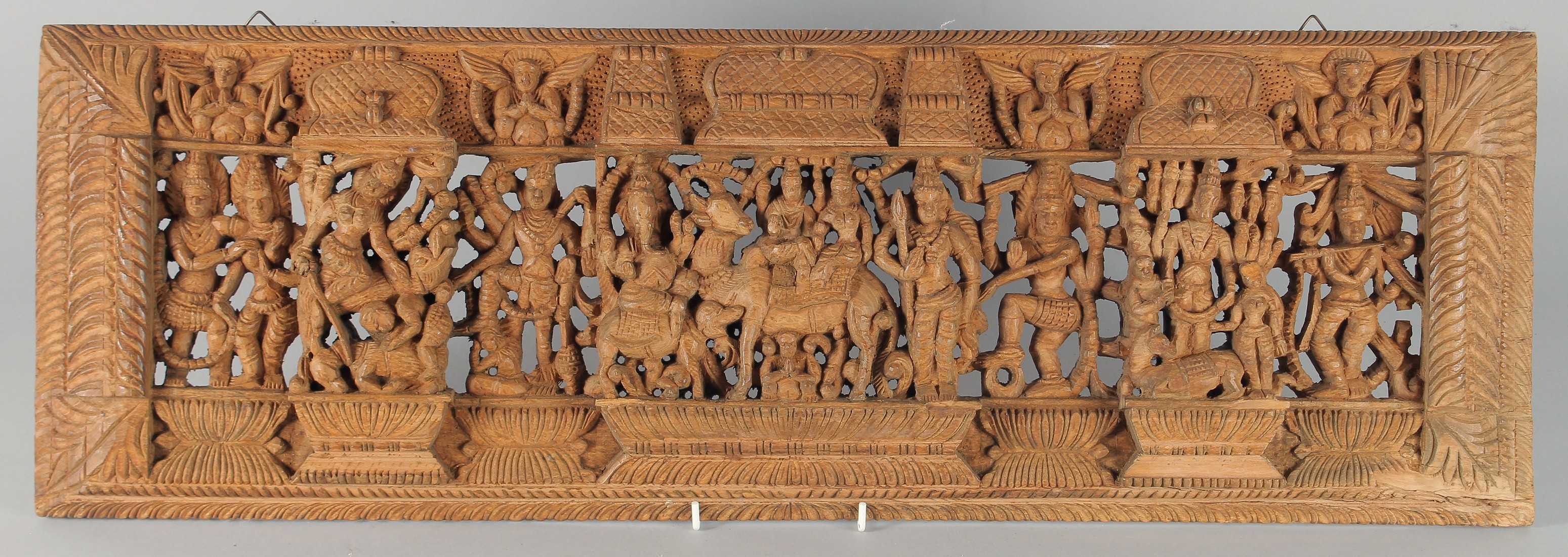 A THAI CARVED AND PIERCED RECTANGULAR WOODEN PANEL, depicting deities, animals and musicians, 73cm x