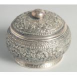 AN CAMBODIAN SILVER CIRCULAR LIDDED BOX, with embossed and engraved foliate decoration, stamped to