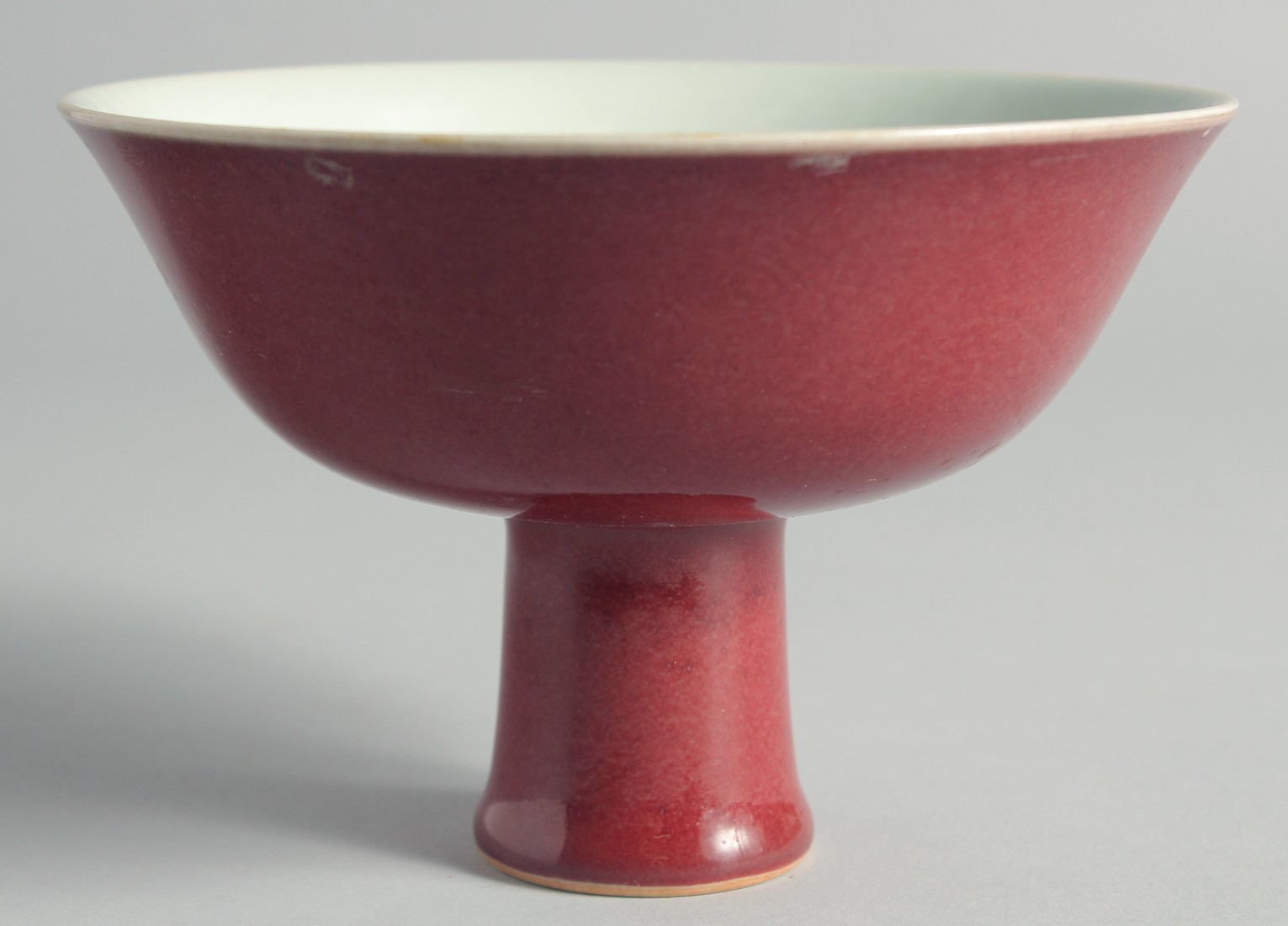 A CHINESE RED GLAZE PEDESTAL BOWL, with six-character mark to inner foot rim, bowl 15cm diameter.