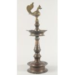 A LARGE INDIAN BRONZE OIL LAMP, the top with bird formed finial, 62cm high.