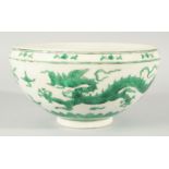 A CHINESE GREEN ENAMELLED PORCELAIN BOWL, decorated with dragons and clouds, 24.5cm diameter.