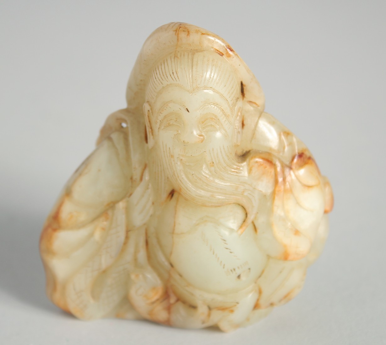 A CHINESE CARVED JADE FIGURE OF AN IMMORTAL, 7.5cm high.