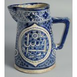 AN ISLAMIC BLUE AND WHITE GLAZED POTTERY EWER, 20.5cm high.