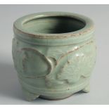 A CHINESE CELADON GLAZE CENSER, relief-decorated with leaves and vine, raised on three feet, 10cm