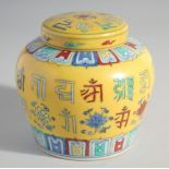 A CHINESE YELLOW GROUND POLYCHROME GINGER JAR AND COVER, painted with characters, 13cm high.