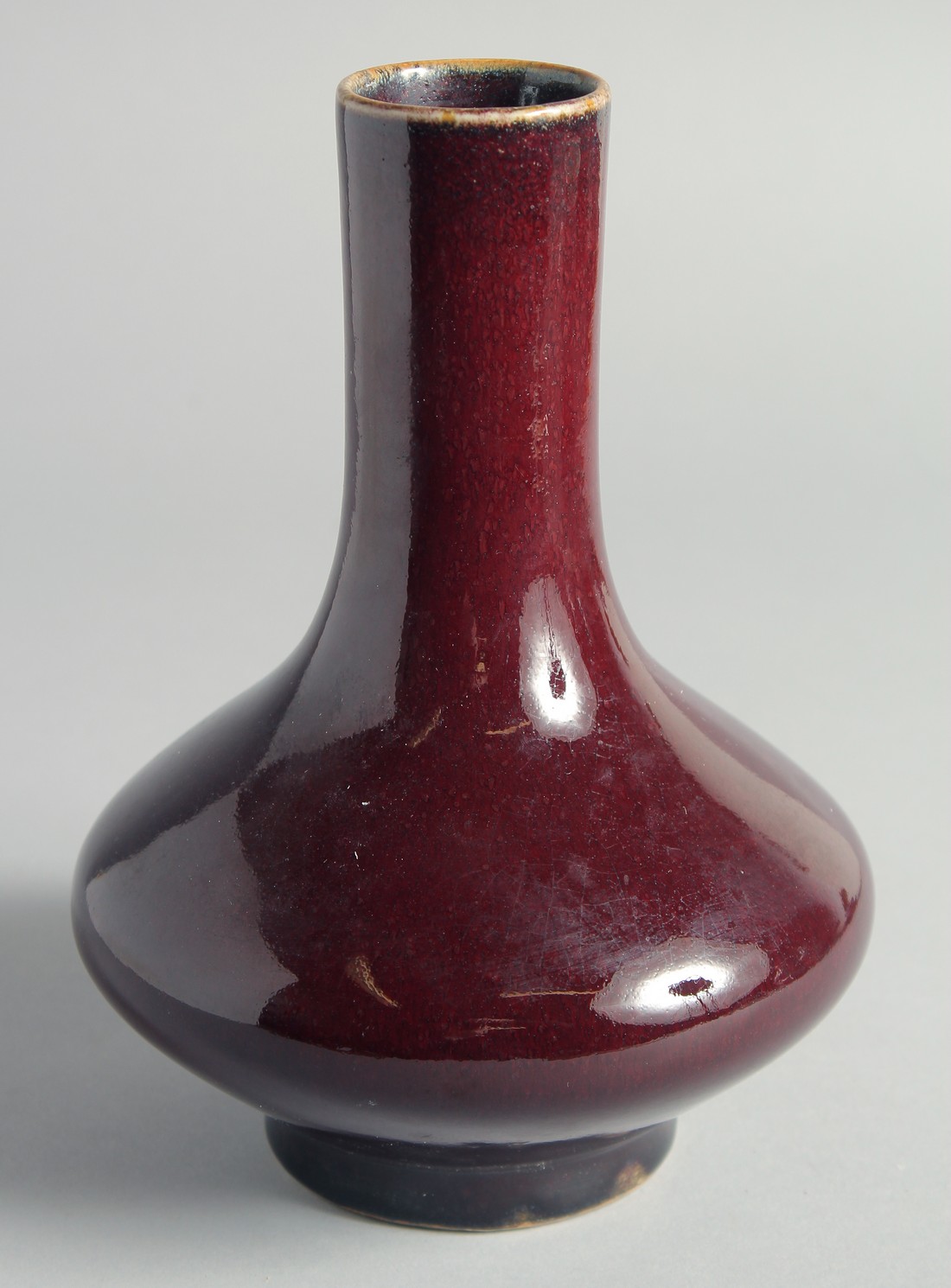 A CHINESE FLAMBE GLAZED BOTTLE VASE, 21cm high.