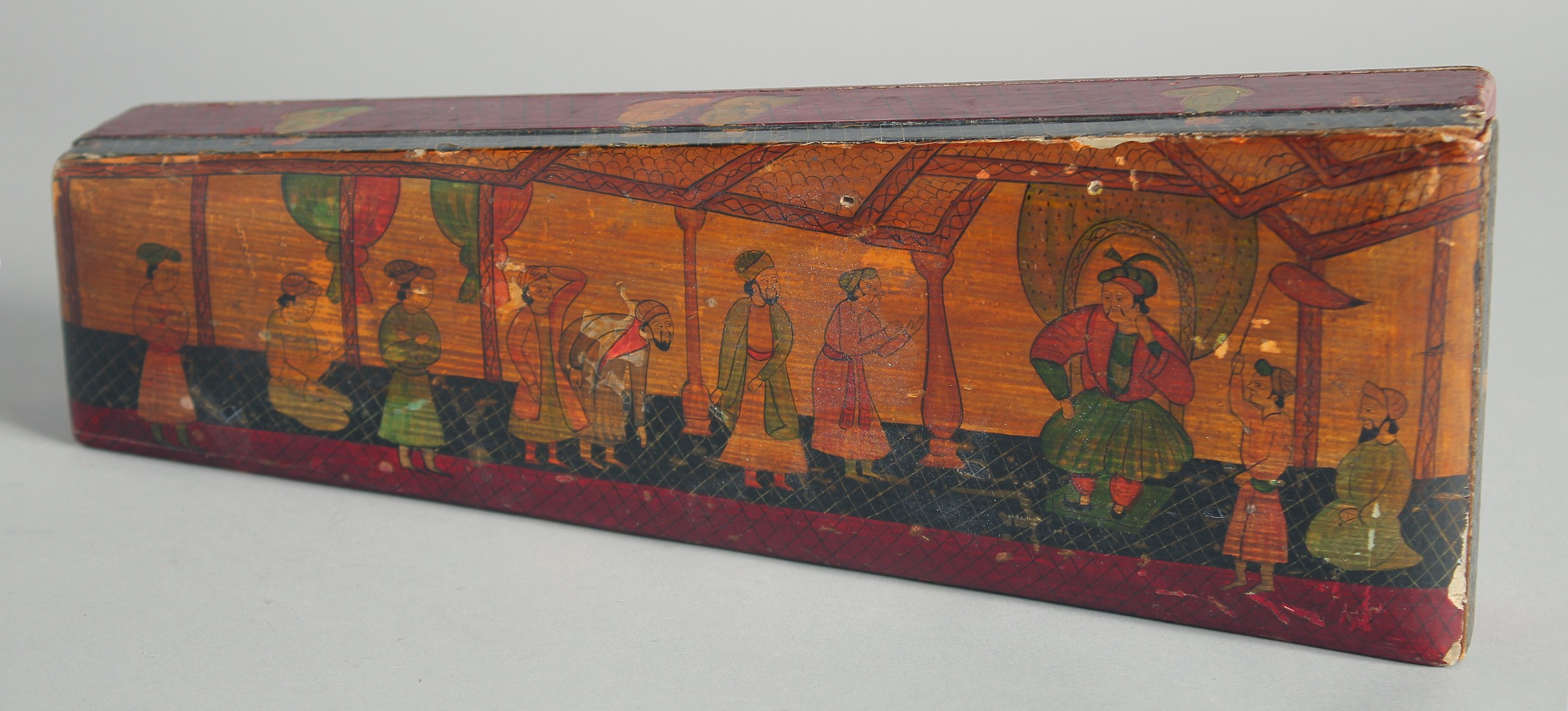 AN INDIAN PAPIER MACHE BOX, painted with a dignitary and attendants, 33.5cm long.