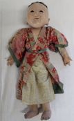 1930s Japanese composition boy doll with fixed glass eyes, wearing traditional kimono over paper