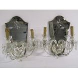 Pair of mirrored wall sconces with electric lighting
