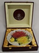 Cased Chinese ceramic plate with raised chrysanthemum decoration (30cm wide) in wooden