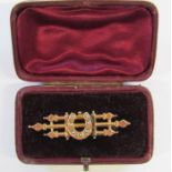 9ct gold brooch with horseshoe design and pearl inset W. 3.5g on metal back