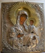 19th century Russian icon of Madonna and child with ornate white metal and gilded embellishments .