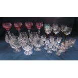 Collection of glassware to include tall stemmed cranberry coloured glasses and crystal brandy