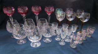 Collection of glassware to include tall stemmed cranberry coloured glasses and crystal brandy