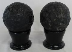 2 cannon balls on ebonised wooden stands