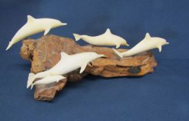 Five dolphins leaping on driftwood sculpture by John Perry