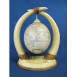 Resin horns with hanging ostrich egg decorated with a transfer print map approx. 26cm tall