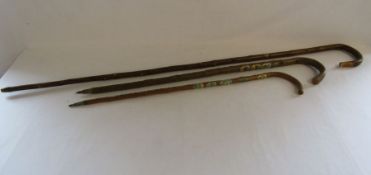2 walking sticks with various stick badges and a shepherds crook