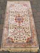 Small ivory ground cashmere rug with central lozenge medallion 143cm by 68cm