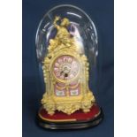 Gilt French timepiece with porcelain panels under glass dome