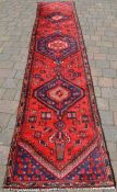 Red ground Persian Hamadan runner with medallion design 360cm by 76cm