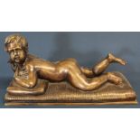 Cast metal figure of reclining young boy holding a bird 40cm wide x 17cm deep