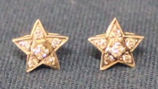 Pair of diamond star cluster earrings set in possibly platinum on gold posts