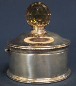 Edwardian circular silver box with hinged cover and hand cut finial - possibly a smoky quartz held