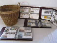 Wicker basket and 4 large folders of Royal Mail first day cover stamps