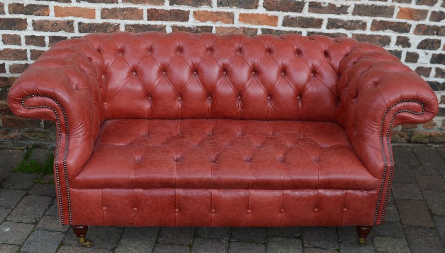 Red leather chesterfield two seater sofa, L170cm